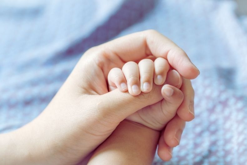 Parent comforting baby with reflux or cow’s milk protein allergy symptoms